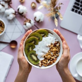 Female,Hand,Holding,Healthy,Breakfast,Bowl,Over,Work,Table,Background